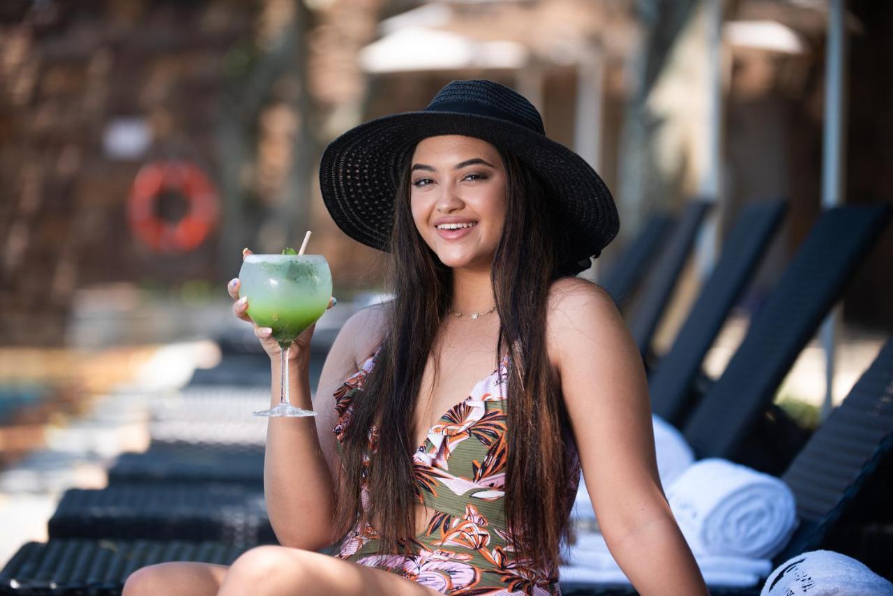The Capital Zimbali Hotel Ballito Kültér fotó A woman wearing a sun hat