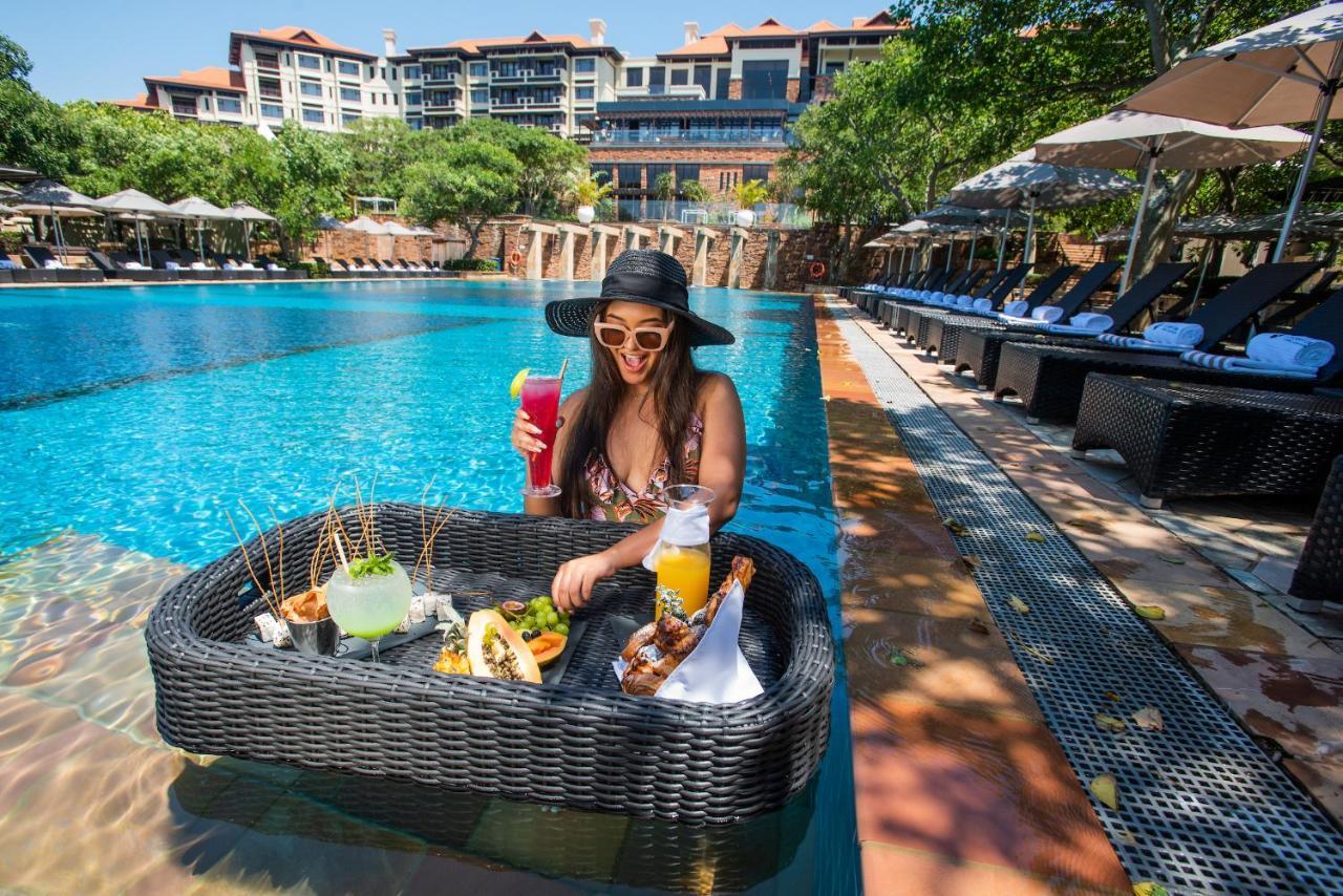The Capital Zimbali Hotel Ballito Kültér fotó A woman at a poolside lounge